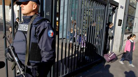 Nach dem Anschlag bewachen Polizisten mit Maschinengewehren das Schulgelände.