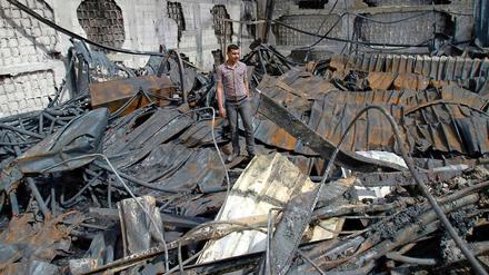 Ein Palästinenser steht in den Trümmern eines durch israelische Luftangriffe zerstörten Warenlagers in Gaza-Stadt.