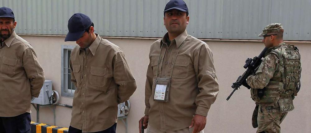 private Sicherheitsleute in Afghanistan, im Hintergrund ein US-Soldat.