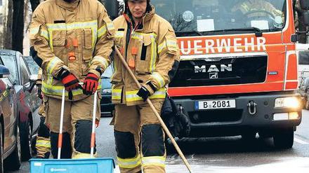 Auf Öl gestoßen. Mehr eine Tonne Bindemittel streuten Feuerwehrleute am Montagvormittag auf eine 13 Kilometer lange Ölspur zwischen Spandau und Wilmersdorf. Welches Fahrzeug geleckt hat, ist unklar. Ein defektes Auto konnte nicht gefunden werden. Foto: dapd