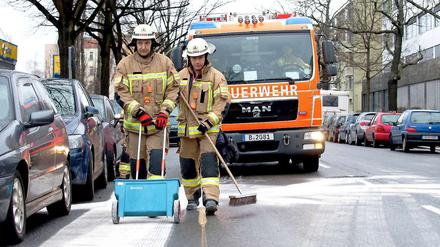Feuerwehleute sind im Einsatz um das Öl zu überstreuen.