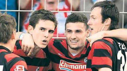 Wir wollen nicht absteigen. Oliver Sorg, Johannes Flum, Daniel Caligiuri und Sebastian Freis (von links nach rechts) bejubeln den Sieg gegen Schalke 04. Foto: dpa