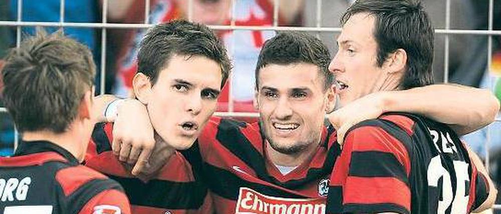 Wir wollen nicht absteigen. Oliver Sorg, Johannes Flum, Daniel Caligiuri und Sebastian Freis (von links nach rechts) bejubeln den Sieg gegen Schalke 04. Foto: dpa