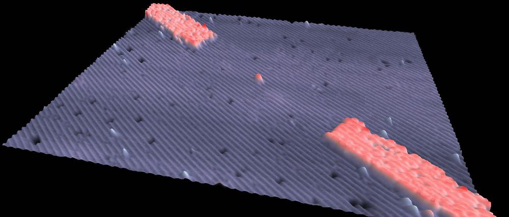 Ein Nanotransistor. Die Mikroskopaufnahme zeigt das Phosphoratom (rot) sowie die elektrischen Kontakte, ebenfalls in Rot.