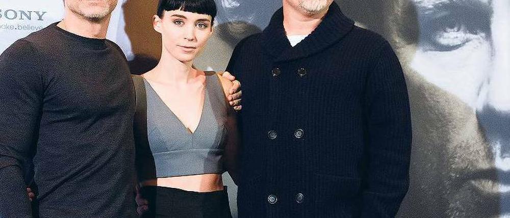 Pulli, Top, Jacke. Daniel Craig, sonst als James Bond aktiv, und Regisseur David Fincher (r.) werben hochgeschlossen für die Stieg-Larsson-Verfilmung „Verblendung“. Hauptdarstellerin Rooney Mara hat dagegen Hitze. Kinostart ist am 12. Januar. Foto: Clemens Bilan/dapd