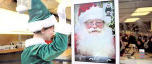 Weihnachtself grüßt Weihnachtsmann. In diesem Apple-Store machen beide Werbung für das iPhone. 