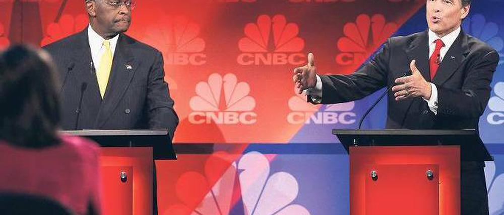 Wahlkampfzirkus. Rick Perry, Gouverneur von Texas, hatte vor einem Millionenpublikum einen schweren Aussetzer und redete sich um Kopf und Kragen. Seither bewegt sein Blackout die ganze Nation. Sein Kontrahent Herman Cain (links) kämpft derweil mit den Vorwürfen mehrerer Frauen, die sich von ihm sexuell belästigt fühlten. Foto: Scott Olson/Getty Images/AFP