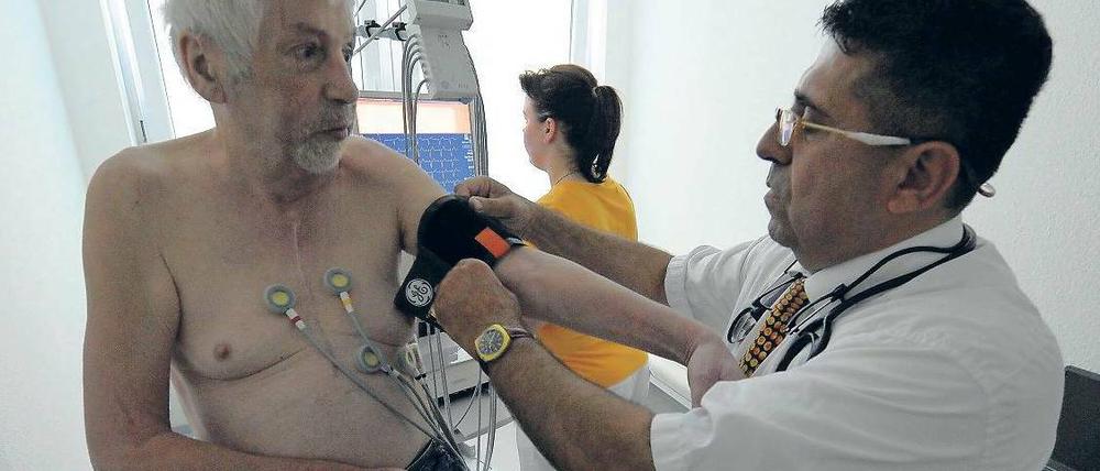 Besser informiert. Mit der Herzstromkurve (EKG), bei deren Messung Elektroden auf der Brustwand platziert werden, kann man sich einen Überblick über den Gesundheitszustand des Herzens verschaffen. Hier untersucht der Arzt Amin Ballouz in seiner Praxis in Schwedt einen Patienten mit dem EKG und einem Blutdruck-Messgerät. Foto: dapd