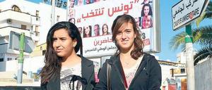 Demokratische Vorfreude. Zwei Studentinnen in Tunis, wo die Parteien vor der Wahl am Sonntag eifrig plakatierten. Insgesamt 90 Listen bewerben sich um Sitze in der verfassunggebenden Versammlung des Landes. 