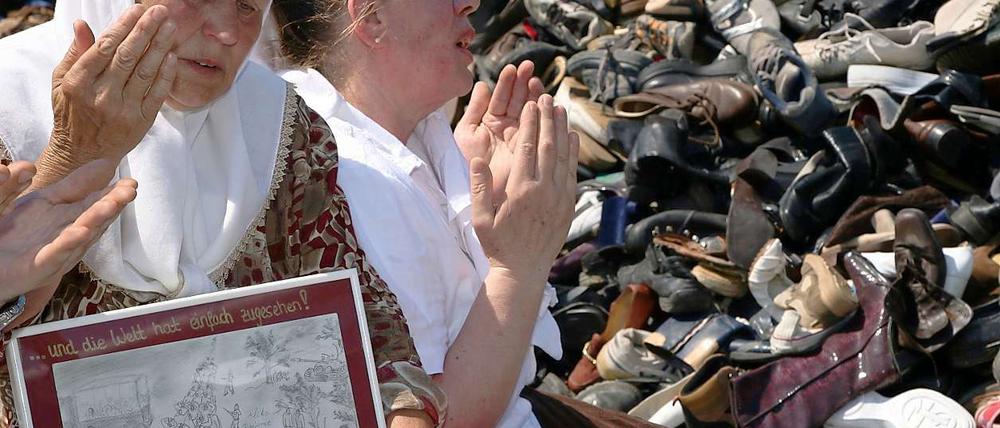 Zwei bosnische Frauen beten am Schuh-Hügel am Brandenburger Tor.
