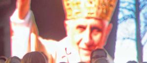 Singen und Warten. In Berlin und anderen Diözesen laufen die Vorbereitungen für den Besuch Benedikts XVI. – wie hier auf Burg Scharfenstein in Thüringen. Dort sang der Jugendchor vor einem Bild des Papstes während einer ökumenischen Lichterfeier. Foto: dapd