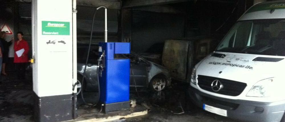 Im Hintergrund ist eines der angezündeten Autos zu sehen, auch der Mercedes im Vordergrund ist beschädigt.