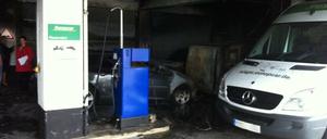 Im Hintergrund ist eines der angezündeten Autos zu sehen, auch der Mercedes im Vordergrund ist beschädigt.