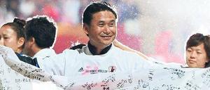 Fahnenkleid. Japans Trainer Norio Sasaki zeigt feiernd Flagge. 