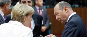 Bundeskanzlerin Merkel und der rumänische Präsident Basescu reden angeregt auf dem EU-Gipfel miteinander.
