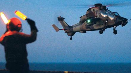 Einsatz gegen Gaddafi: Ein französischer „Tiger“-Transporthubschrauber bereitet sich nach einem nächtlichen Einsatz in Libyen auf die Landung auf dem Flugzeugträger „Tonnerre“ vor. Leiter der Libyen-Operation ist der kanadische General Bouchard. Foto: Joel Saget/AFP