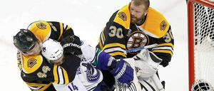 Helm ab zum Ringkampf: Dennis Seidenberg im Clinch mit Alex Burrows (Vancouver), der Bostons Torwart Tim Thomas zuvor die Kopfbedeckung heruntergeschlagen hat.