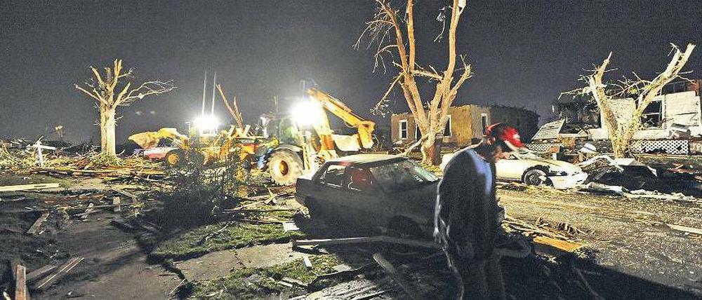 Kahle Äste ragen in den Himmel. Der Überlebende Tedd Grabenauer läuft in der Nacht fassungslos durch die Stadt, wo der Tornado Häuser vom Boden radiert hat. Foto: dpa