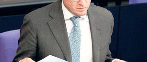 Karl-Theodor zu Guttenberg mit einem Exemplar seiner Doktorarbeit am 23. Februar im Bundestag. Die Uni Bayreuth bescheinigt ihm „defizitären Arbeitsstil“. Foto: dpa