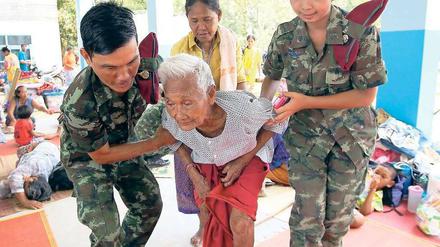Zivilisten in Not. Thailändische Soldaten helfen einem Dorfbewohner. Foto: dpa