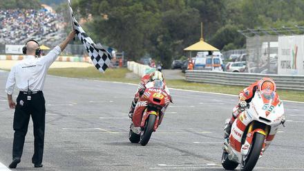 Helm runter. Stefan Bradl (rechts) rast auf seiner Maschine zum Sieg. Foto: AFP