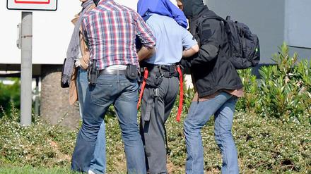 Einer der drei mutmaßlichen Terrorverdächtigen wird am Samstag auf dem Gelände des Bundesgerichtshofes in Karlsruhe aus einem Hubschrauber geführt.
