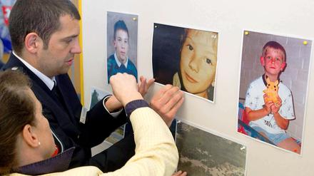 Ermittler in Verden hängen vor einer Pressekonferenz Fotos der ermordeten Kinder auf.