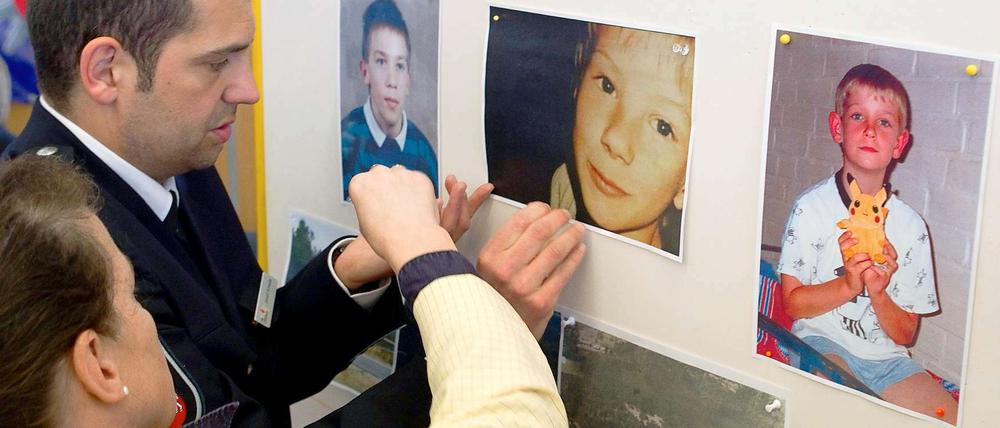Ermittler in Verden hängen vor einer Pressekonferenz Fotos der ermordeten Kinder auf.