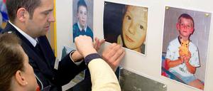 Ermittler in Verden hängen vor einer Pressekonferenz Fotos der ermordeten Kinder auf.