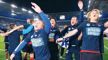 Perfekte Welle. Herthas Spieler konnten sich schon lange auf den Aufstieg einstellen, am Montagabend durften sie in Duisburg mit ihren „Mission erfüllt“-Shirts jubeln. Foto: Reuters