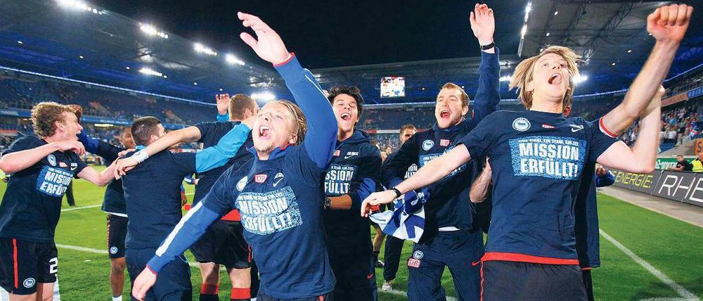 Perfekte Welle. Herthas Spieler konnten sich schon lange auf den Aufstieg einstellen, am Montagabend durften sie in Duisburg mit ihren „Mission erfüllt“-Shirts jubeln. Foto: Reuters