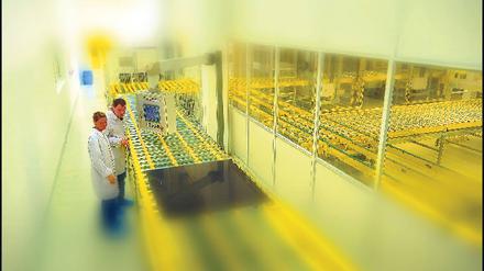 Saubere Sache. Mitarbeiter der Inventux Technologies in Berlin-Marzahn überprüfen ein Dünnschicht-Solarmodul.