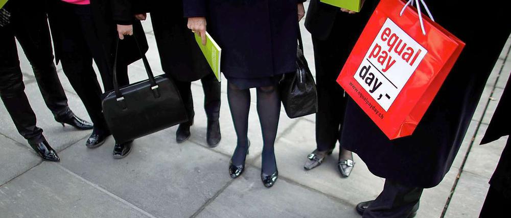 Die roten Taschen sollen an die Differenz in den Lohntüten erinnern.