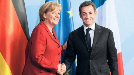 Pakt für den Euro. Kanzlerin Merkel und Frankreichs Präsident Sarkozy müssen Zugeständnisse an kleinere EU-Partner machen. Foto: dpa