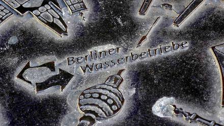Ein Kanaldeckel mit dem Firmenzeichen der Berliner Wasserbetriebe.