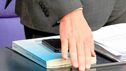 Unter der Hand: Verteidigungsminister Karl-Theodor zu Guttenberg beantwortet am Mittwoch Fragen zu seiner Promotion - und hat diese vorbildlicherweise auch dabei.