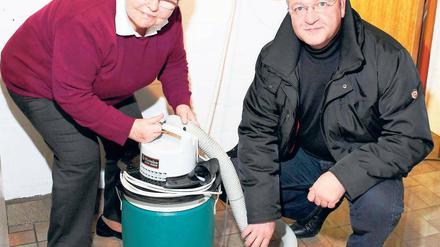 Deichgraf, eins tiefer: Gisela Kirste zeigt Frank Henkel ihren Wassersauger. Zehn Eimer Grundwasser saugt sie damit täglich auf – und das schon seit November. 