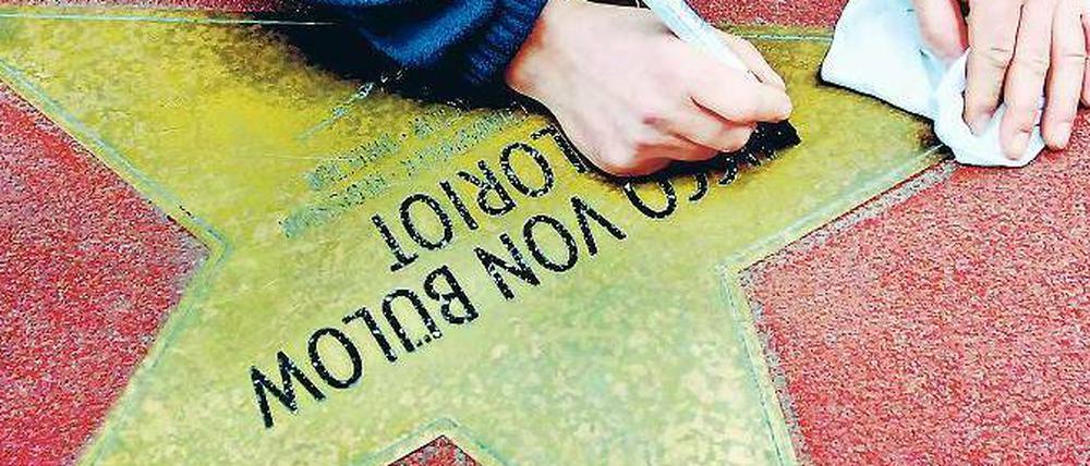 Neuer Glanz für Loriot: Mit einem Eddingstift malt Bodo Lehmann die Namen und Unterschriften der Promis auf dem Boulevard der Stars nach, hier den von Vicco von Bülow. 