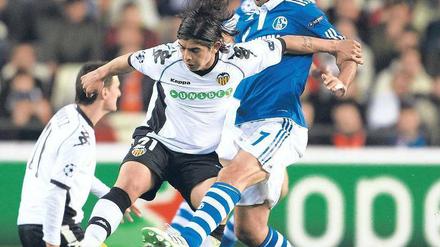 Raúl stoppt Valencia. Schalkes Spanier (rechts, im Zweikampf mit Ever Banega) erzielte gegen seine Landsleute das wichtige Tor zum 1:1. Es war für Rekordtorschütze Raúl bereits der 69. Treffer in der Champions League. Foto: dpa