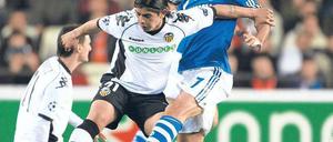 Raúl stoppt Valencia. Schalkes Spanier (rechts, im Zweikampf mit Ever Banega) erzielte gegen seine Landsleute das wichtige Tor zum 1:1. Es war für Rekordtorschütze Raúl bereits der 69. Treffer in der Champions League. Foto: dpa
