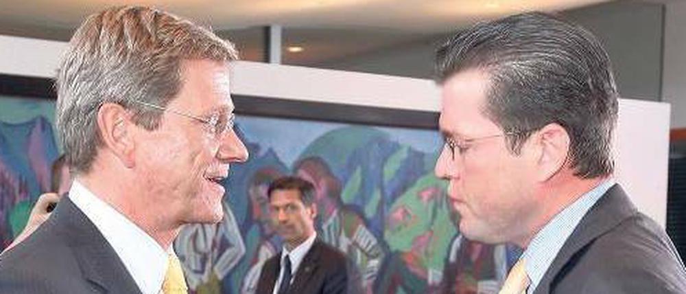 Telefonate mit der Kanzlerin. FDP-Chef Westerwelle (links) klagt, dass Verteidigungsminister Guttenberg den Eindruck einer zerstrittenen Koalition schüre.