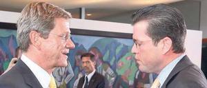 Telefonate mit der Kanzlerin. FDP-Chef Westerwelle (links) klagt, dass Verteidigungsminister Guttenberg den Eindruck einer zerstrittenen Koalition schüre.