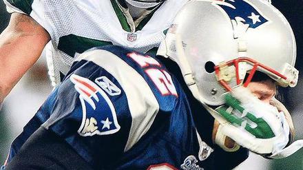 Leaving on a Jet Plane. Patriots-Quarterback Tom Brady wird von Jets-Cornerback Drew Coleman gestoppt. Foto: dpa