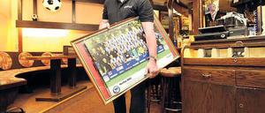 Trauer zum Abschied. Ex-Hertha-Fußballer Hans Weiner schleppt Bilder und Wimpel aus seiner Kneipe an der Joachimstaler Straße. Kurz nach Mitternacht hat er dichtgemacht. Der Mietvertrag konnte nicht verlängert werden. Kommt nun eine Donuts-Filiale? Foto: Jürgen Engler