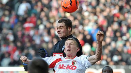 Lasogga überspringt Augsburgs Bellinghausen im Kopfballduell. Doch den Sprung an die Spitze hat Hertha verpasst.