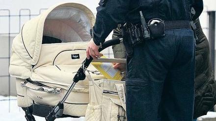 Geborenenkontrolle. Ein Polizist checkt einen verdächtigen Kinderwagen.