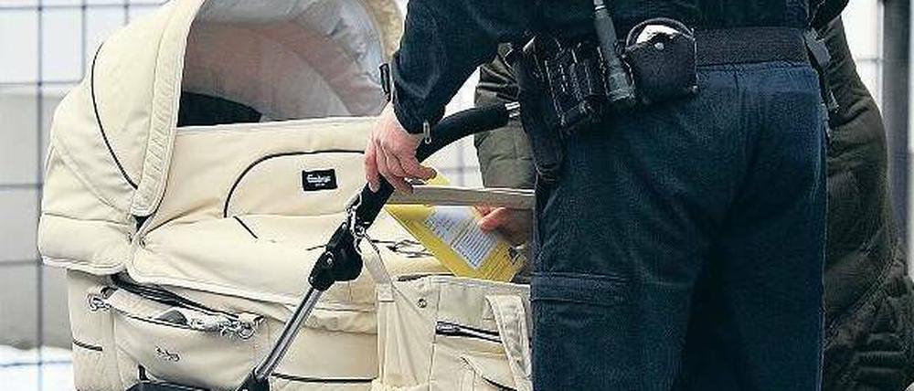 Geborenenkontrolle. Ein Polizist checkt einen verdächtigen Kinderwagen.