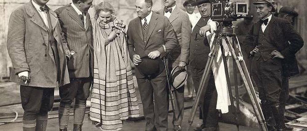 Verhüllte Diva. Im Herbst 1925 wurde die Überschwemmung der Arbeiterstadt gedreht. Bei einer Drehpause posierten vor dem Standfotografen der Kameramann Günther Rittau, Regisseur Fritz Lang, Brigitte Helm, der US-Kinobesitzer Samuel L. Rothafel, ein Unbekannter, Kameramann Karl Freund und sein Assistent Robert Boberske (v. l.).