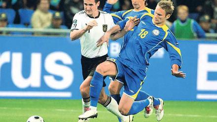 Im Mittelpunkt. Miroslav Klose (links) setzte sich erst gegen den Kasachen Maxim Asowski durch, schoss später sein 58. Länderspieltor und musste den Platz in Astana dann verletzt verlassen. Foto: dpa