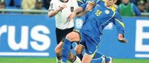 Im Mittelpunkt. Miroslav Klose (links) setzte sich erst gegen den Kasachen Maxim Asowski durch, schoss später sein 58. Länderspieltor und musste den Platz in Astana dann verletzt verlassen. Foto: dpa